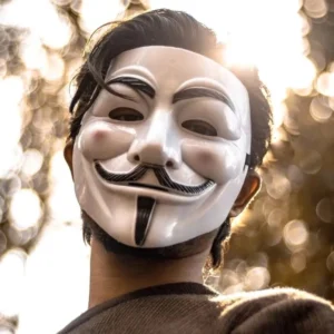 Steampunk Guy Fawkes white mask worn by male model, outdoor portrait with bokeh background, showcasing realistic wear and styling possibilities