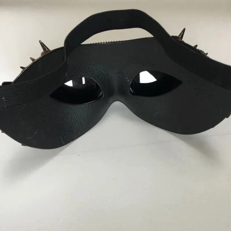 Matte black steampunk half eye mask with small spike trims and adjustable elastic headband, front angle