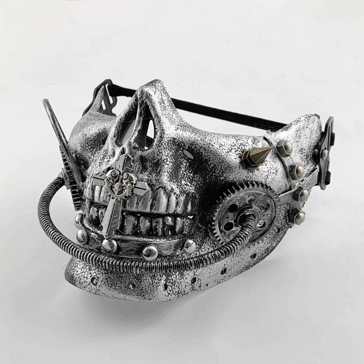 Steampunk half skull mask with aged silver faux metal texture, intricate brass gears, ornamental spikes, rivets, and decorative cross accent on the jaw, displayed on white studio background