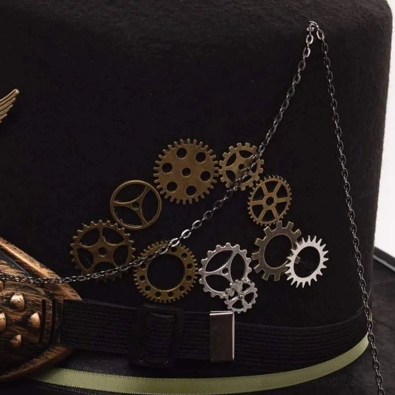 Steampunk top hat crown close-up displaying mixed metal gears in brass and silver tones, hanging decorative metal chain, and green ribbon belt detail