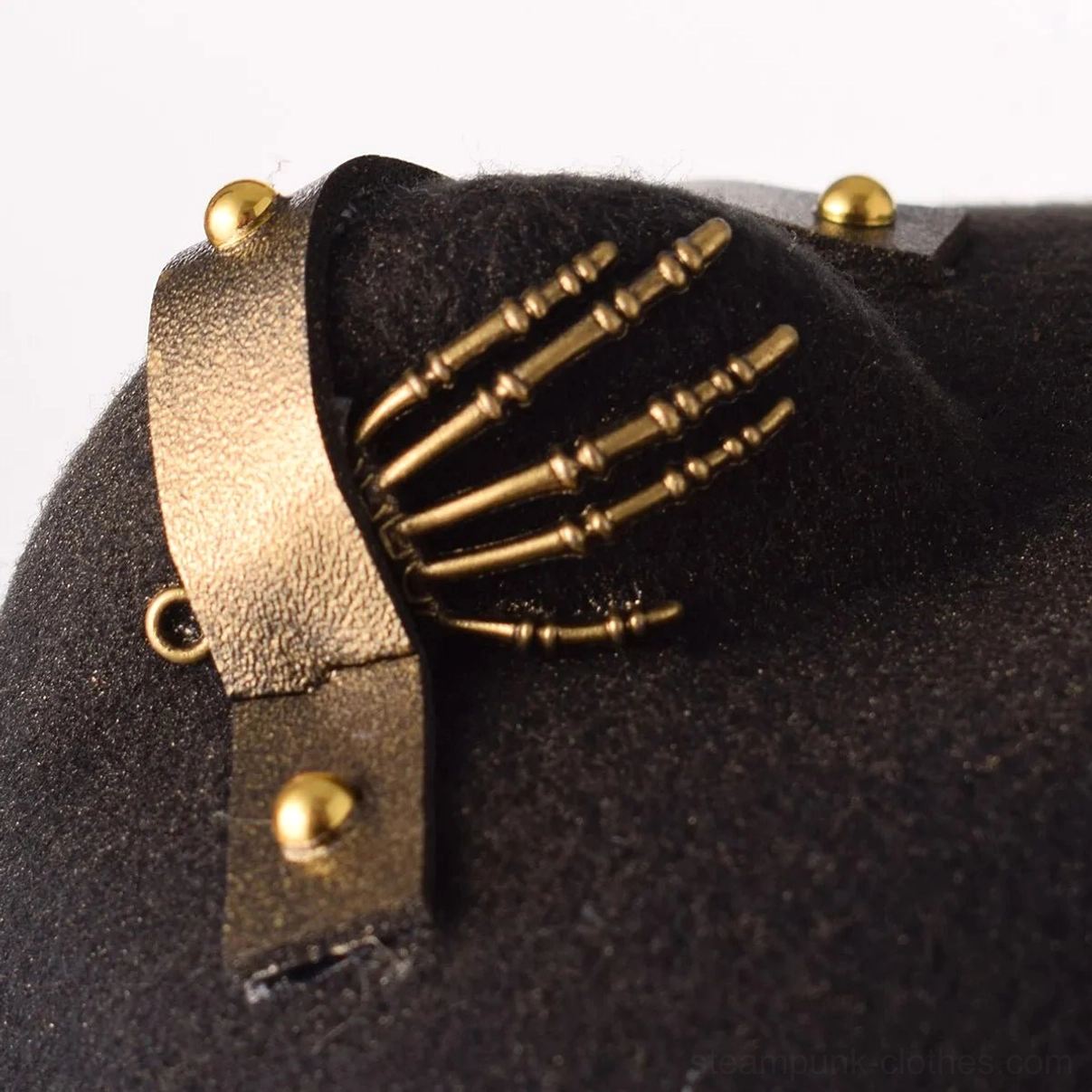 Close-up top detail of steampunk hat with brass skeleton hand decor and leather strap gold studs