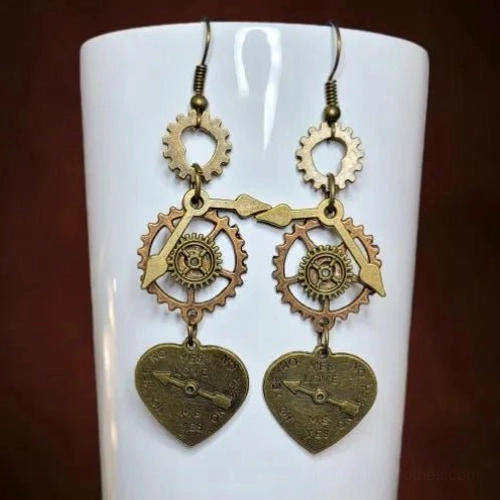 Steampunk heart dangle earrings displayed on white ceramic cup with mixed copper bronze tones