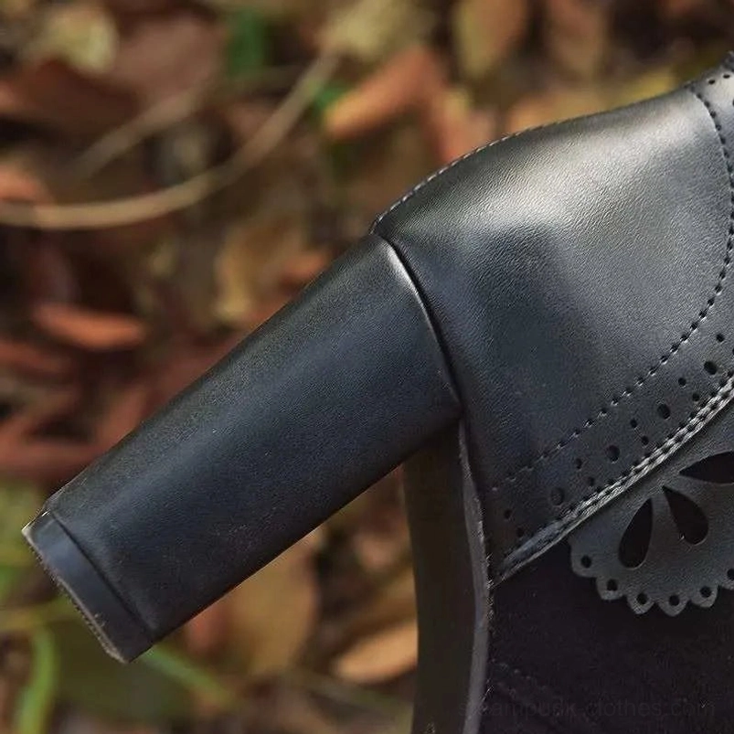 Close-up low-angle view of black steampunk boot heel showing perforated scalloped leather trim and architectural block heel design
