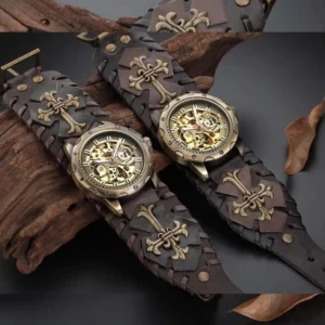 Steampunk hollow mechanical wristwatch with exposed bronze skeleton movement and cross-pattern dark brown leather strap, shot in overhead view against weathered wood and dry leaves