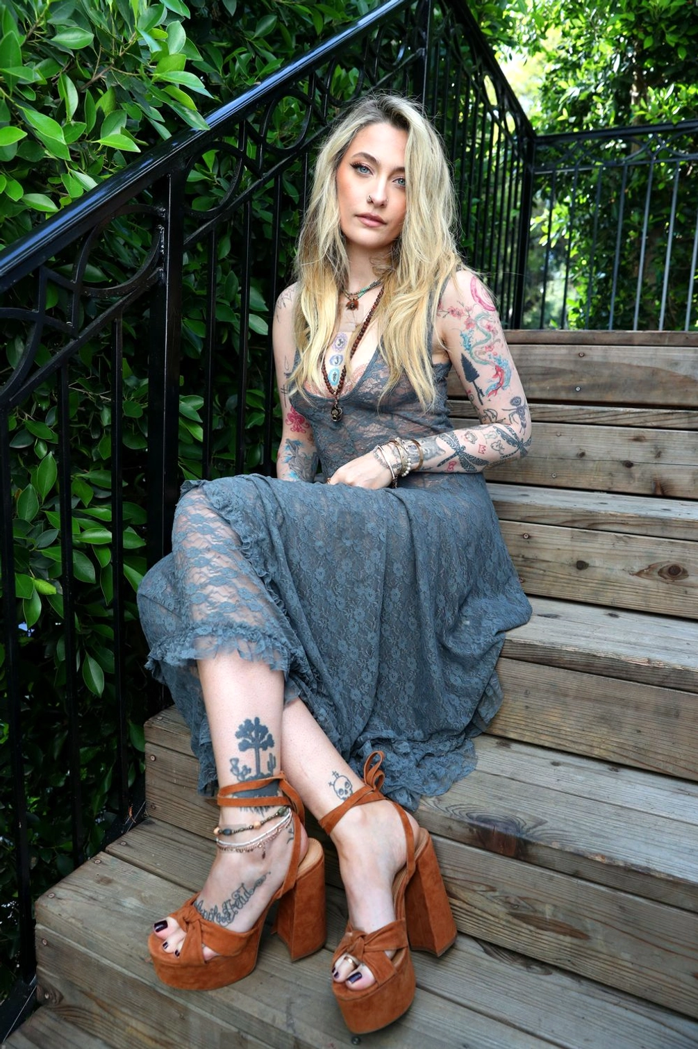 Grey lace steampunk dress worn outdoors on model showing v-neck asymmetrical design