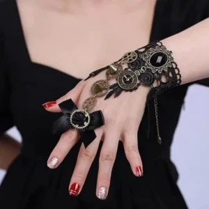 Steampunk lace hand jewelry with dangling chain, gear decorations and black gem accent on side profile, vintage-inspired hand cuff on female model