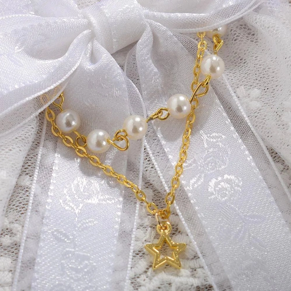Close-up detail of white steampunk lace gloves showing faux pearls, gold chain, star pendant, embossed ribbon, and intricate lace texture