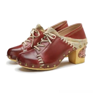 Steampunk lace-up leather boots with brass studs and engraved details, front three-quarter view featuring burgundy leather and canvas panel