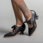 Black steampunk lace-up pumps with floral cutout design, rear side view showcasing leather texture and heel profile