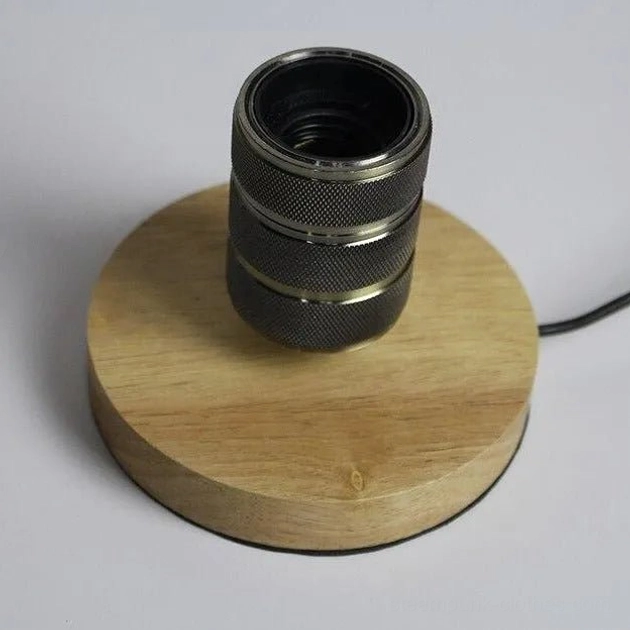 Steampunk table lamp base and socket assembly overhead view with light wood base black knurled metal socket and attached power cord studio background