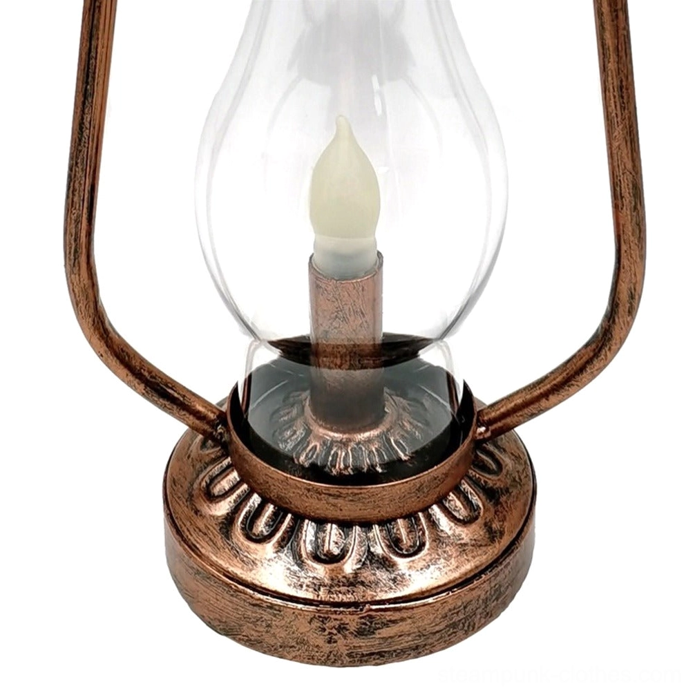 Close-up detail of steampunk lamp showing embossed bronze base and spring-mounted metal handle, direct front view