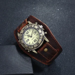 Steampunk quartz watch flat lay featuring distressed leather band, compass-style bronze bezel, and cream-colored face with Arabic numerals on dark speckled tabletop