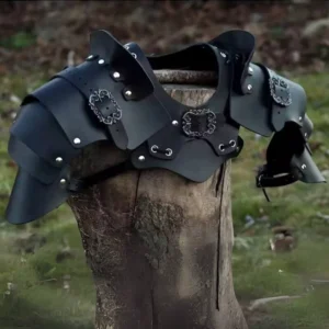 Black steampunk leather shoulder and chest armor featuring silver rivets and ornate carved buckles, displayed on wooden tree stump in lush woodland setting, left three-quarter angle detail view highlighting layered construction and metallic hardware accents