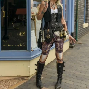 Steampunk printed leggings with bronze mechanical gear pattern worn by female cosplayer in outdoor brick setting with complete steampunk outfit