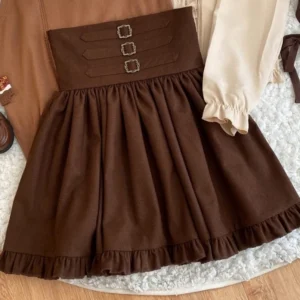 Steampunk lolita skirt flat lay on wooden table with beige ruffled blouse showing waistband detail and pleated skirt construction