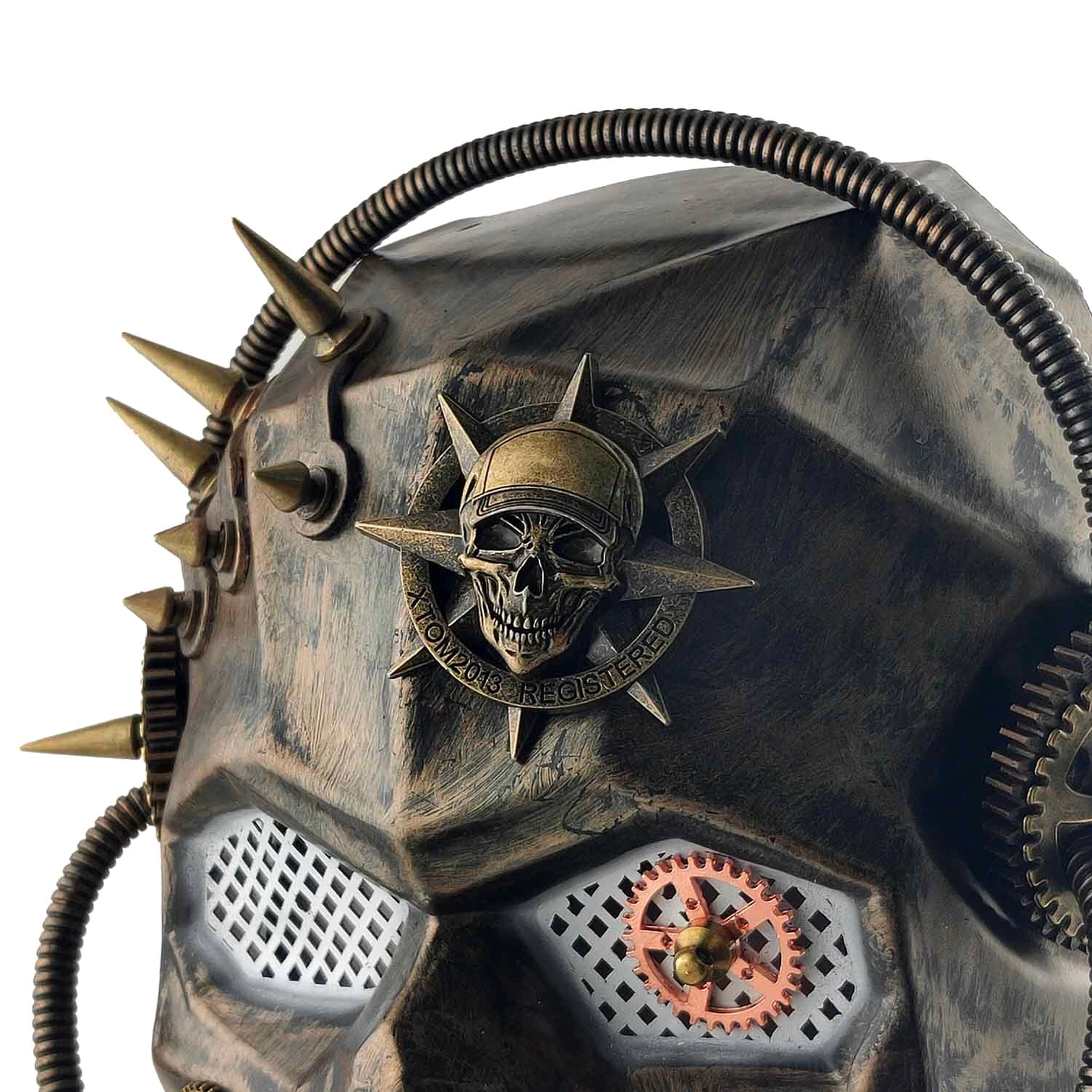 Close-up detail view of steampunk mask front-left angle featuring embossed skull badge, sharp metal spikes, aged bronze distressed texture, and geared mesh eye cover mechanism