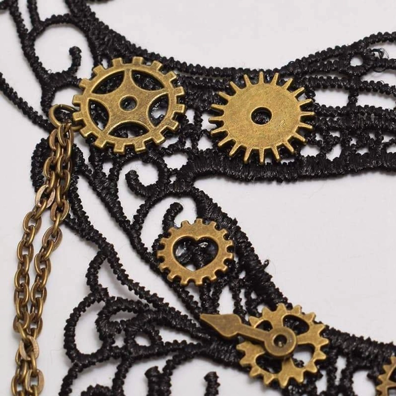 Close-up detail of steampunk mask showing black crochet lace texture, brass gears, clock hand embellishments, and linked metal chains