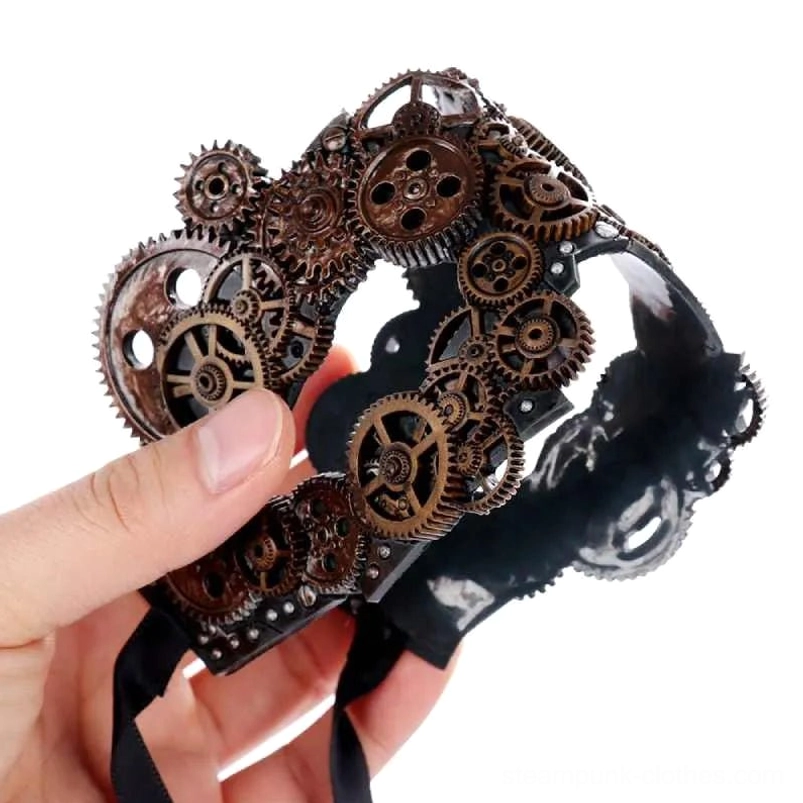 Black PVC steampunk masquerade mask held in hand, showing side profile with riveted base and decorative gear ornaments