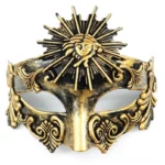 Steampunk masquerade face mask with aged gold-black finish featuring intricate sun god relief ornament and vintage scroll carvings, front flat view on white background