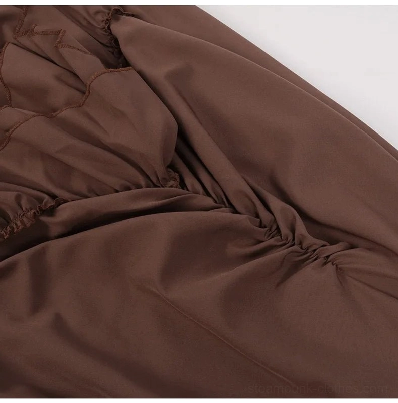 Close-up texture detail of brown steampunk skirt fabric showing matte satin weave and stitched ruffled seams