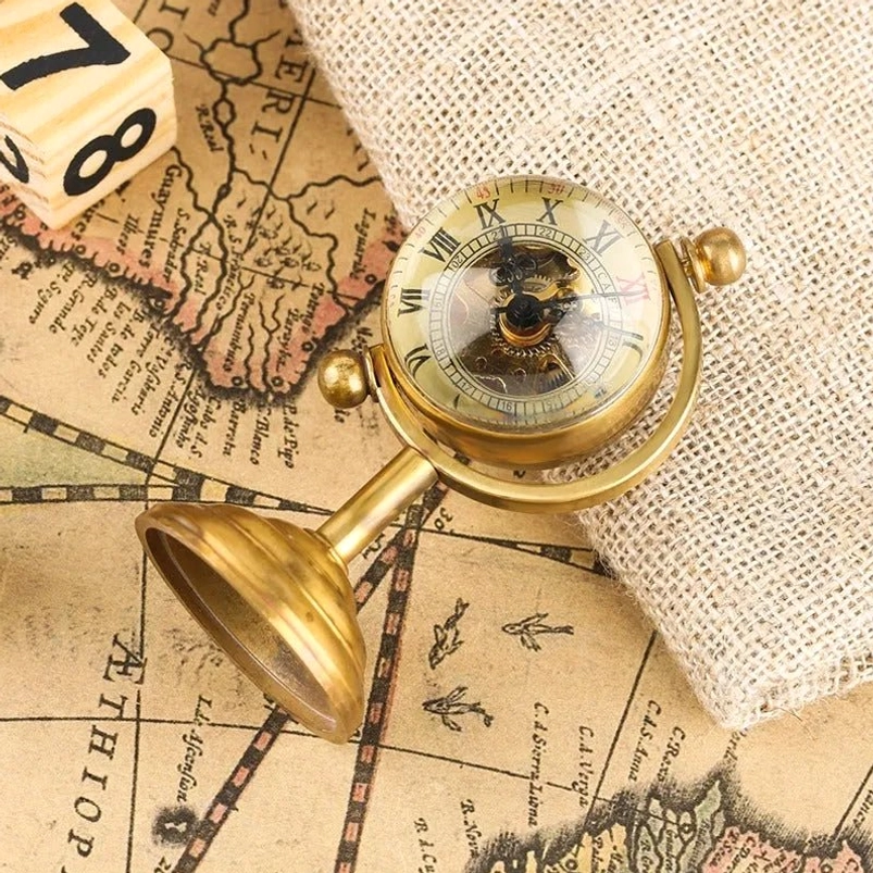 Steampunk mechanical globe clock overhead tilted view with exposed mechanical movement, brass metal base, vintage map and burlap fabric styling