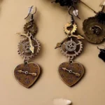 Steampunk heart earrings with bronze gears and arrow details on tabletop display