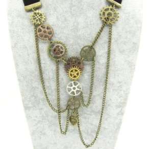Vintage steampunk necklace with mixed metal gears and engraved heart pendant displayed on velvet jewelry stand