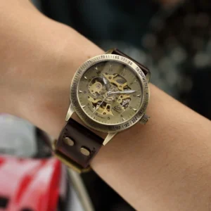 Skeleton steampunk watch worn on wrist demonstrating fit and bronze case finish with leather strap - side angle