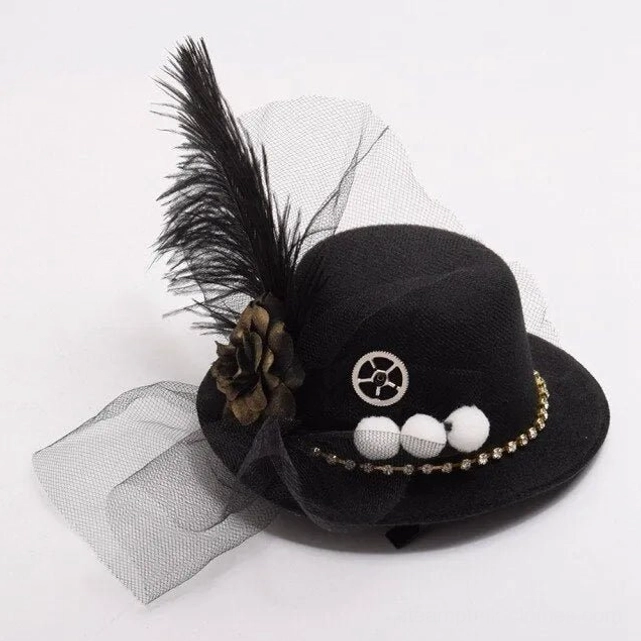 Front top view of black steampunk mini fedora with rhinestone trim, feather, tulle, and pom-pom embellishments highlighting gothic details