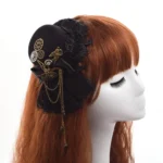 Steampunk mini top hat with black lace and vintage gear tassel worn on mannequin head, showing right side profile view with auburn long hair background