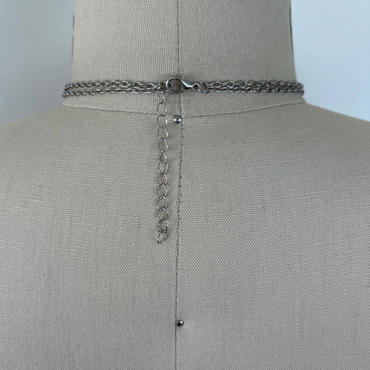 Adjustable steampunk necklace clasp and extension chain detail showing lobster claw fastening and silver-toned cable chain construction