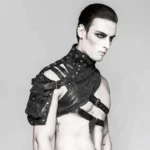 Male model wearing black asymmetrical one-shoulder steampunk armor with industrial rivets, metal buckles, and adjustable cross-straps, front three-quarter view on neutral background