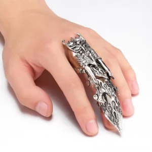 Articulated steampunk owl finger armor worn on left hand, showcasing the articulated dual-loop design, antique silver-plated finish with intricate flame engravings, and sculpted owl head detail in side profile view