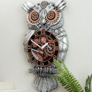 Distressed silver steampunk owl clock full body shot against light wall with green foliage backdrop, showcasing hand-carved resin construction and exposed gear design elements