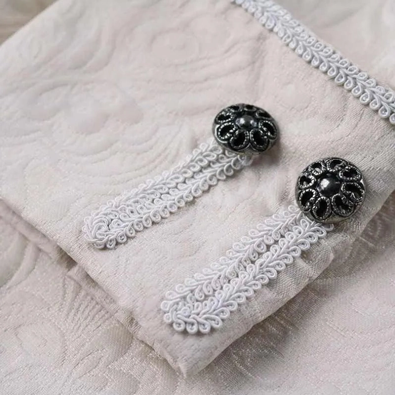 Ornate vintage metal buttons and braid strap decorations on steampunk palace jacket cuff