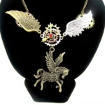 Steampunk Pegasus necklace worn on display bust featuring bronze dual-tone wings, intricate gear accents, and red crystal centerpiece against black velvet background