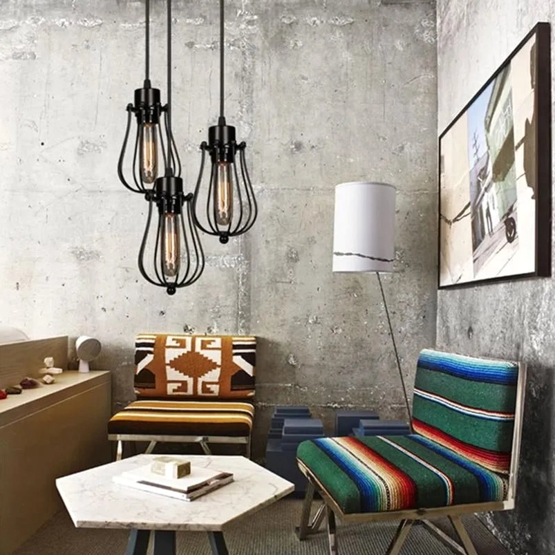 Multiple steampunk cage pendant lamps installed in industrial bohemian living room with vintage furniture and warm ambient lighting