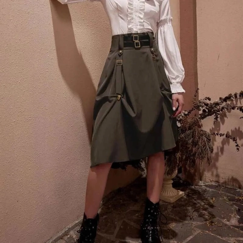 Female model wearing high-waist steampunk pirate skirt styled with white ruffled top and black boots, outdoor vintage courtyard setting, side view