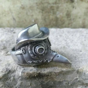 Left side profile of steampunk plague doctor statement ring displaying aged silver metal construction, decorative stitching, mechanical goggle details and ornate ring band