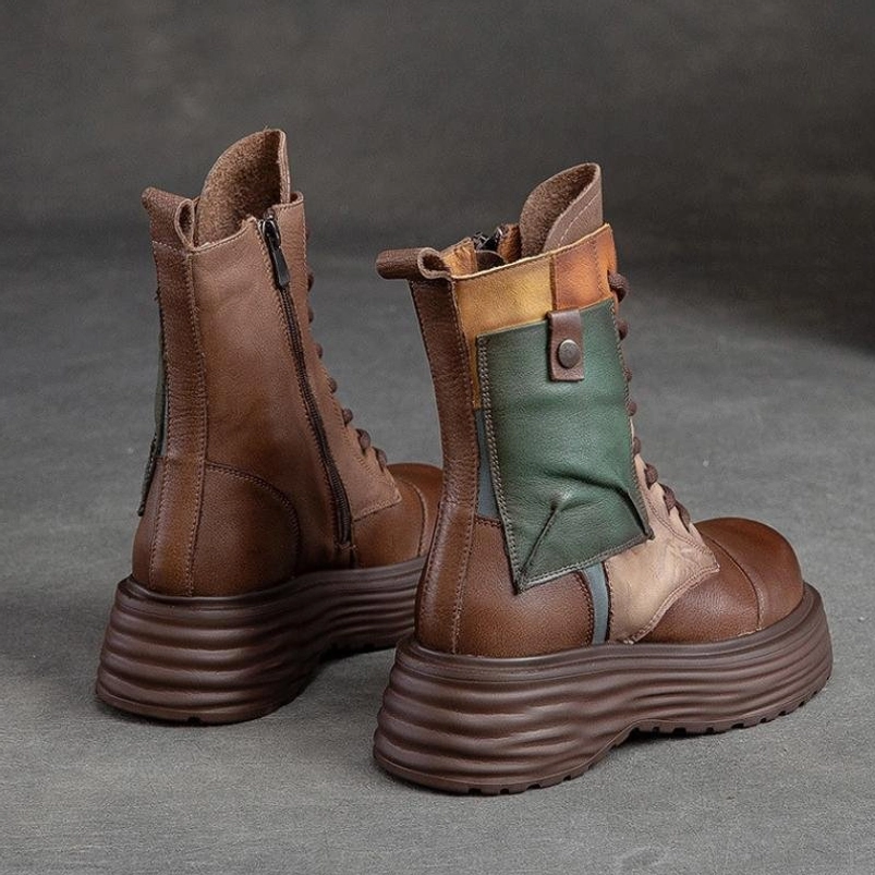 Steampunk combat boots rear three-quarter perspective displaying contrast panel design, heel pull tab, and industrial side zipper on genuine leather upper