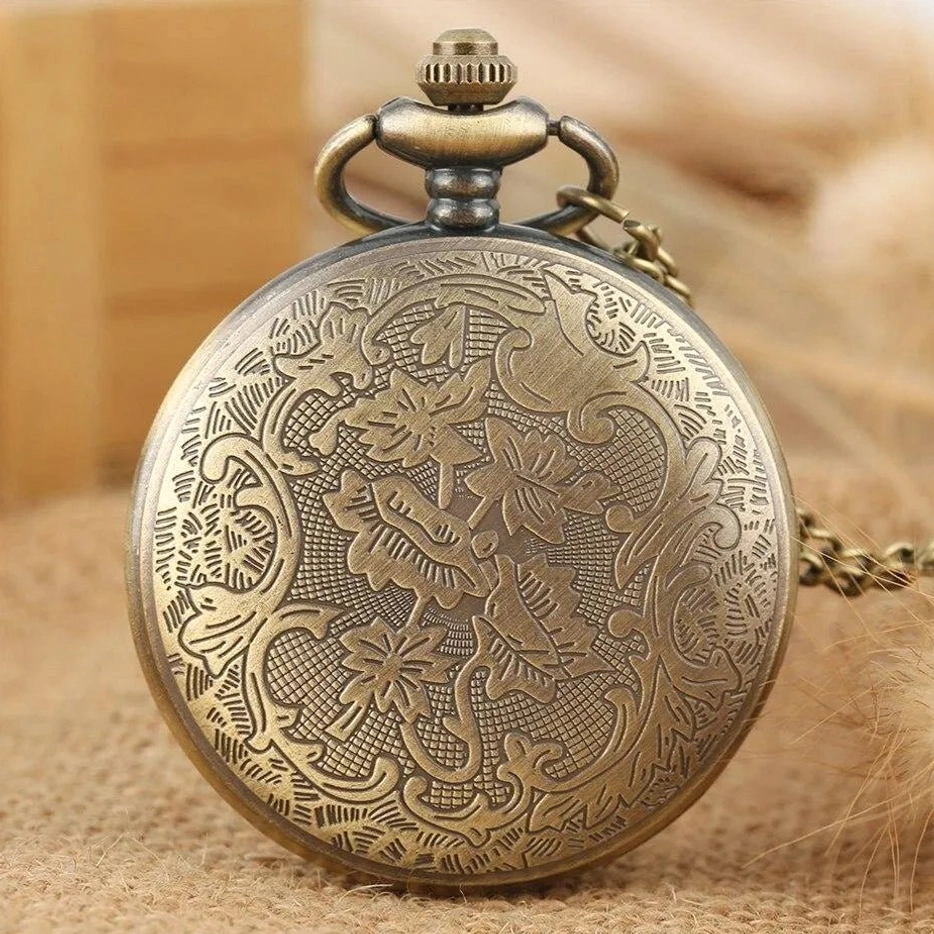 Steampunk pocket watch back cover with engraved scroll and flower patterns across full surface, vintage bronze-tone metalwork detail