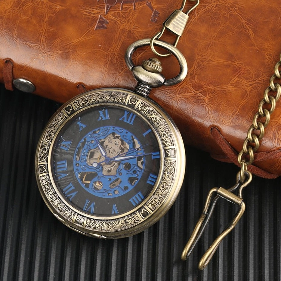 Blue steampunk pocket watch with exposed mechanical gears and carved bronze case, shown at oblique angle with brown leather wallet and metal chain