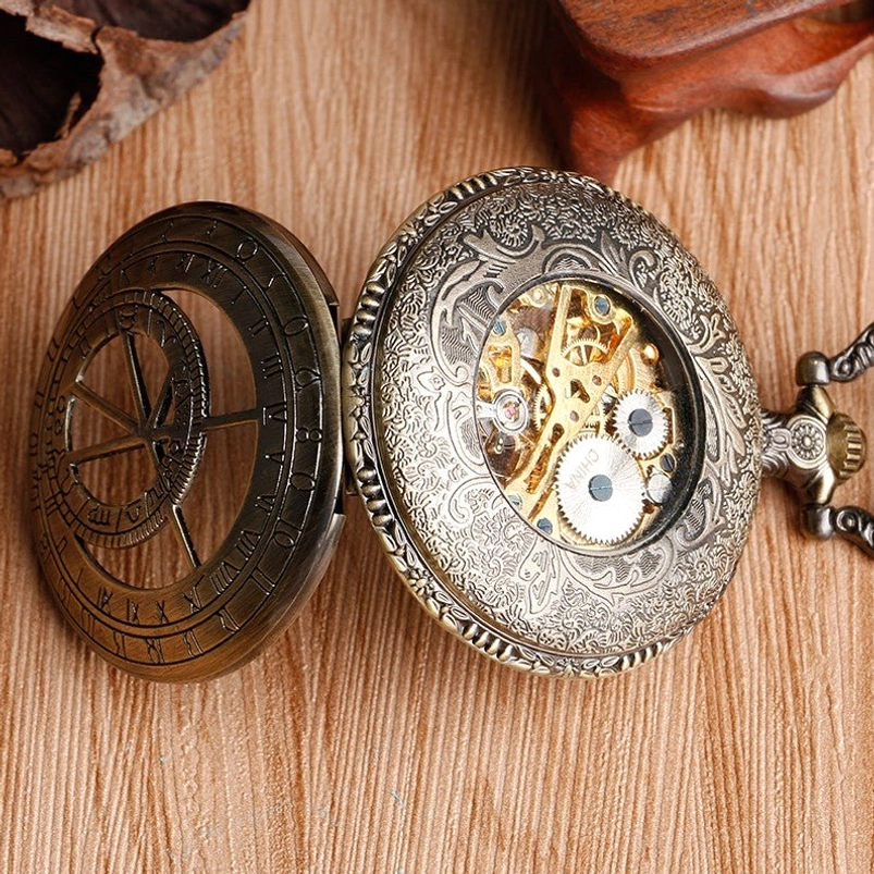 Steampunk skeleton pocket watch case separated showing two-tone bronze and silver construction with floral carved design and hollowed astrolabe panel detail