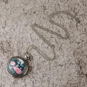 Silver-toned steampunk pocket watch flat lay with linked chain - women's quartz timepiece with decorative artwork