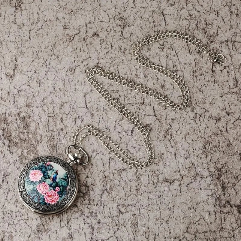 Silver-toned steampunk pocket watch flat lay with linked chain - women's quartz timepiece with decorative artwork