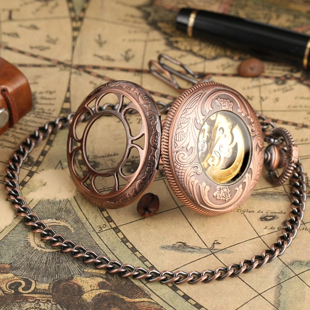 Steampunk pocket watch with detached hollow flip cover displaying relief pattern on back cover and metal pocket chain on vintage map desk