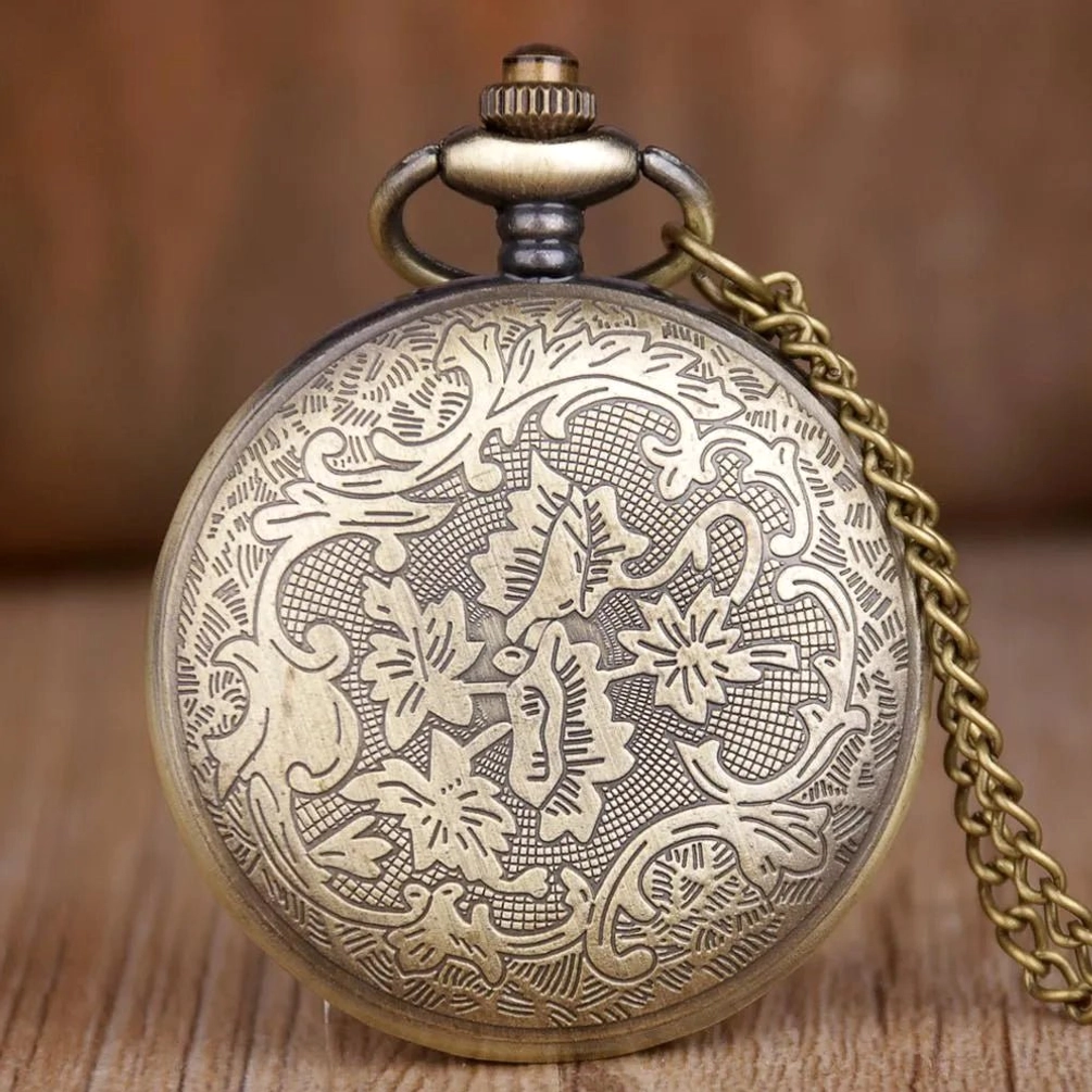 Back view of vintage engraved steampunk pocket watch showcasing ornate floral vine engravings and bronze metal finish on rear cover