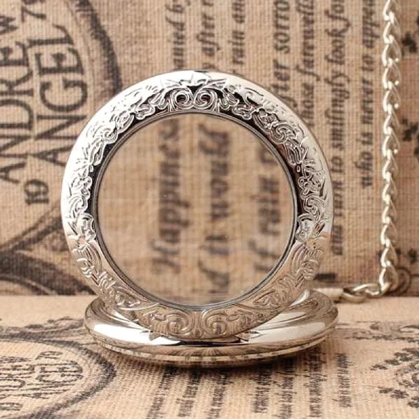 Ornate scroll engraved steampunk pocket watch bezel with attached metal chain detailed view