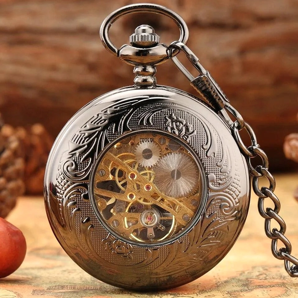 Closed steampunk pocket watch with floral engraved cover and movement window revealing golden internal mechanism