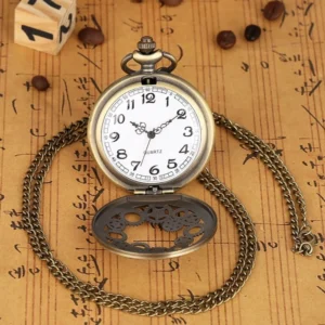 Flip cover steampunk pocket watch flat lay with bronze frame, white Arabic numeral dial, hollow gear engraved flip cover, and long metal chain on vintage paper backdrop